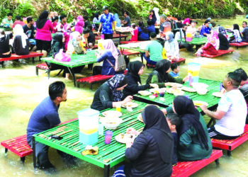 ORANG ramai menikmati makanan sambil bersantai di dalam sungai ketika cuaca panas di Kafe Rimba Kuala Kedua, Baling.