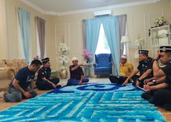 Pegawai dan anggota polis IPD Jempol dan Balai Polis Batu Kikir menziarahi Abd. Rahman Samad (tiga dari kiri) dan Amir Zulhairi (kiri) di rumahnya di Kampung Serting Tengah, Jempol hari ini.-UTUSAN/NOR AINNA HAMZAH.