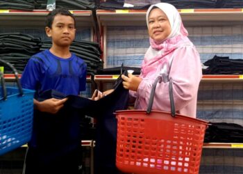 NORWIDYATY Manap membeli barangan persekolahan bersama anaknya menggunakan baucer bantuan persekolahan dalam program Back To School di sebuah pasar raya di Slim River, Tanjung Malim, Perak baru-baru ini. - UTUSAN/MEGAT LUTFI MEGAT RAHIM
