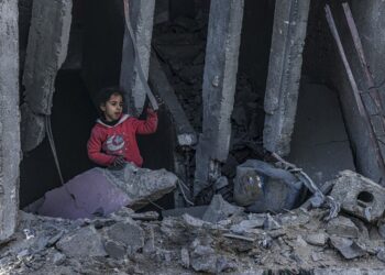 SEORANG kanak-kanak Palestin berdiri di celah-celah runtuhan bangunan yang musnah dalam serangan udara Israel ke atas Rafah, semalam.  – AFP