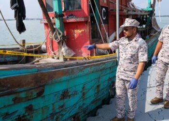 ABDUL Muhaimin Muhammad Salleh (kiri) menunjukkan sebuah bot yang dipercayai digunakan untuk menyeludup keluar dadah jenis syabu di jeti nelayan Sekinchan, Sabak Bernam, Selangor, kelmarin. - UTUSAN/SADDAM YUSOFF