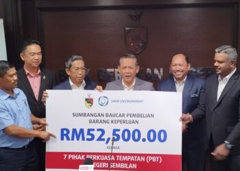 AMINUDDIN Harun (tengah) menerima sumbangan daripada Pengurus Besar Korporat SWM Environment, Mohd. Norlisam Mohd. Nordin (kiri) bagi program SWM Kasih Misi Sampul Merah di Wisma Negeri, Seremban hari ini.-UTUSAN/NAZARUDIN SHAHARI.