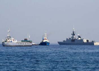 TONGKANG Jenifer, sebahagian daripada tiga kapal flotila yang membawa bantuan makanan untuk Gaza, belayar di sebelah kapal frigat Perancis Courbet ketika flotilla itu berlepas dari pelabuhan Larnaca di Cyprus, kelmarin.-AFP