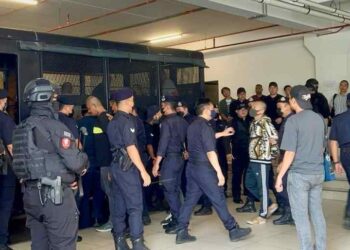 AHLI kumpulan ‘Geng Upik’ diiring ketat oleh pasukan polis di pekarangan Kompleks Mahkamah Kota Kinabalu hari ini