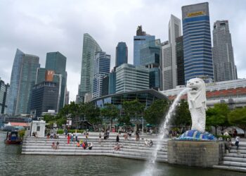ORANG ramai duduk berehat berhampiran patung Merlion di Singapura. - AFP