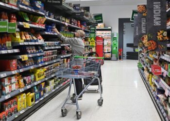 PELANGGAN sedang memilih barangan di pasar raya Asda di Aylesbury, England. - AFP