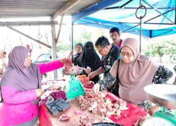 ERDAWATI Ali (kiri) melayan para pelanggan di kedai runcitnya di Jalan Kampung Paya, Kluang. -UTUSAN/LUQMAN