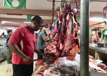 SEORANG peniaga memotong daging lembu untuk dijual kepada pelanggan di Pasar Siti Khadijah, Kota Bharu, Kelantan semalam.- UTUSAN/ ROSLIZA MOHAMED