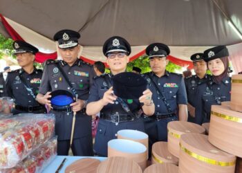 MAT Yaacob (tengah) menunjukkan songkok yang dihasilkan oleh penghuni Pusat Pemulihan Akhlak Machang dan hasil tangan prospek penjara di gerai jualan di Majlis Sambutan Hari Penjara Ke-234 Peringkat Negeri Kelantan di Penjara Pengkalan Chepa, Kota Bharu, Kelantan hari ini. -UTUSAN/MUSTAQIM MOHAMED