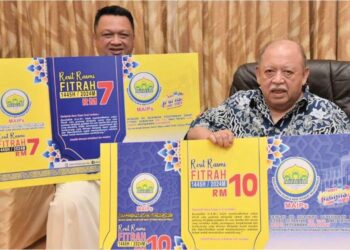 TUANKU Syed Sirajuddin Jamalullail (kanan) dan Raja Muda Perlis, Tuanku Syed Faizuddin Putra Jamalullail berkenan menunjukkan kadar zakat fitrah
di negeri itu.