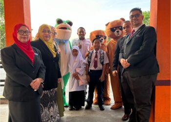 MOHD. Halim Arafulla (tengah) bersama guru dan maskot menyambut kedatangan murid pada hari pertama persekolahan di SK Tasik Damai di Ipoh, hari ini. -  UTUSAN/LIYANA RAMLI