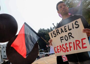 PENUNJUK perasaan memegang plakad menggesa pelaksanaan gencatan senjata di Gaza. - AFP