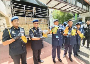 WAN Jamal Abdul Salam Wan Long (tiga, kanan) dan Azman Ismail (dua, kiri) menunjukkan minyak peket bersubsidi yang dirampas dalam serbuan di  Jambatan Kampung Kubang Panjang,  Tumpat, Kelantan.
– UTUSAN/YATIMIN ABDULLAH