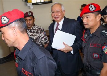 NAJIB Razak diiringi pegawai penjara ketika hadir di Mahkamah Tinggi Kuala Lumpur semalam untuk sambung bicara kes pecah amanah dan pelanggaran kewajipan statutori berkaitan dana SRC International.
– UTUSAN/SADDAM YUSOFF