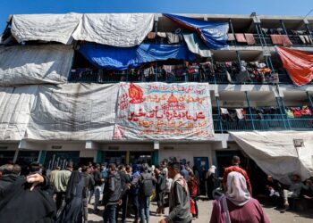 PENDUDUK Gaza beratur untuk mendapatkan bantuan makanan dan keperluan di kem perlindungan sementara di Rafah di Semenanjung Gaza.-AFP 