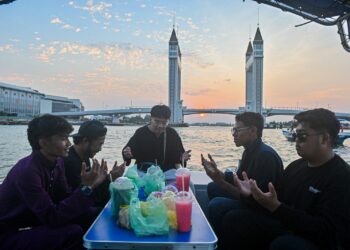 BEBERAPA penumpang bot berbuka puasa sambil menyusuri Sungai Terengganu berdekatan Jabatan Angkat Kuala Terengganu di Kuala Terengganu, kelmarin. - UTUSAN/PUQTRA HAIRRY ROSLI