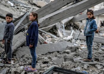 KANAK-kanak Palestin melihat runtuhan bangunan selepas ia musnah dalam serangan Israel pada malam sebelumnya, di kejiranan Rimal di Kota Gaza pada 16 Mac lalu. – AFP