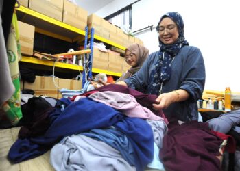 ROSIDAH Ismail melipat tudung yang siap dijahit untuk dibekalkan kepada para pelanggannya di premis Jannah Anggun di Taman Mutiara Rini, Johor Bahru.