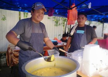 ZAMBRY Ahmad (kiri) menunjukkan hidangan menu istimewa ikan patin masak tempoyak yang dijualnya di Bazar Ramadan Bandar Baru Nilai, Seremban. - UTUSAN/NUR SHARIEZA ISMAIL.