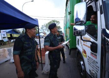 SHEIK Azhar Sheik Omar (dua dari kiri) memeriksa lori dalam sekatan jalan raya di Chabang Empat Salam, Rantau Panjang, Kelantan. -UTUSAN/KAMARUL BISMI KAMARUZAMAN