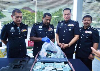 HUSSEIN Omar Khan (dua dari kiri) menunjukkan bagasi berisi wang tunai melebihi RM500,000 yang ditemukan di parkir sebuah pusat beli-belah di Damansara, Selangor, hari ini.
