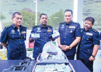 HUSSEIN Omar Khan (dua dari kiri) menunjukkan bagasi berisi wang tunai melebihi RM500,000 yang ditemukan di parkir sebuah pusat beli-belah di Damansara, Selangor. - UTUSAN/SYAKIR RADIN