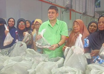 Gary Ko (tengah) bergambar bersama beberapa penerima program sumbangan makanan laut sempena Ramadan di Taman Mount Austin, Johor Bahru, hari ini.
