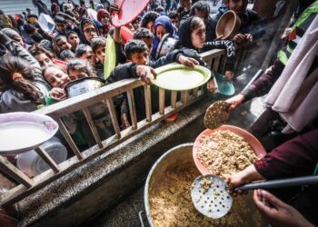 KANAK-KANAK Palestin berkumpul untuk menerima makanan di sebuah sekolah kerajaan di Rafah, selatan Gaza, 19 Februari lalu. – AFP