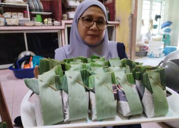 GAYAH Yaacob menunjukkan tepung boko ubi kayu yang dibungkus dalam daun pisang di Kampung Tok Dor,  Besut. - UTUSAN/WAN ZURATIKAH IFFAH WAN ZULKIFLI