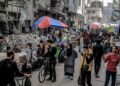 PENDUDUK Palestin membeli barang keperluan di pasar terbuka berhampiran runtuhan di Gaza City.-AFP
