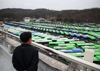SEORANG pemandu melihat ratusan bas yang diletakkan di sebuah depoh akibat mogok di Seoul, Korea Selatan.-AGENSI