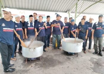 Ahmad Maslan (lima dari kiri) mengacau bubur lambuk di Pontian, Johor, hari  ini. - UTUSAN/MUHAMMAD ZIKRI