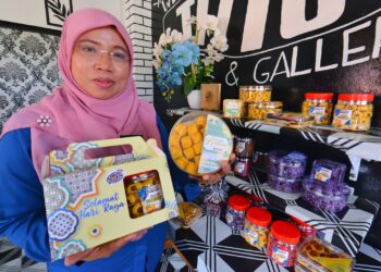 NORASIKEN Ahmad menunjukkan hasil produk kuih tart dan beberapa jenis kuih dan biskut yang dihasilkan oleh klien Puspen Jelebu.--UTUSAN/MOHD. SHAHJEHAN MAAMIN.