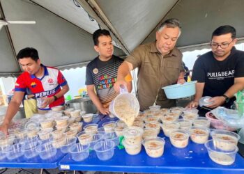 ROZABIL Abd Rahman (dua dari kanan) membantu memasukkan bubur lambuk ke dalam bekas untuk diedarkan buat orang ramai sekitar kawasan Arau, Perlis semalam. -UTUSAN/ASYRAF MUHAMMAD