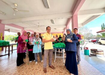 GURU-guru dan jawatankuasa PIBG bergotong-royong menyediakan 1,500 bekas bubur lambuk yang diagikan kepada murid-murid dan warga sekolah berkenaan di Sekolah Tengku Budriah (STB), Arau, Perlis hari ini.- UTUSAN/MOHD. HAFIZ ABD. MUTALIB