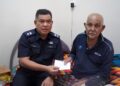 AZli Mohd. Noor (kiri) menyampaikan sumbangan wang tunai Hari Raya Aidilfitri kepada Abdullah Sutan Kudun sempena Sambutan Hari Peringatan Polis Ke-217 di Kampung Tanjung Buluh di Lipis, Pahang. - UTUSAN/HARIS FADILAH AHMAD