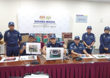 Aminul Izmeer (duduk tengah) menunjukkan gambar keadaan seorang lelaki Singapura yang ditemui bersembunyi di bahagian but belakang Perodua Myvi di CIQ BSI, Johor Bahru.