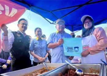 MEGAT Hashirat Hasan (dua dari kanan) dan Ismuni Bohari (kiri) meninjau salah sebuah gerai sewaktu Program Kick Off Food Safey di Bazar Ramadan Persiaran Wawasan, Kangar, Perlis, semalam. -UTUSAN/ASYRAF MUHAMMAD.