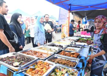 NORAZAH Jaapar (tiga dari kiri) meninjau harga makanan di Bazar Ramadan Rahmah Madani Arau, Perlis, semalam. -UTUSAN/IZLIZAN OTHMAN