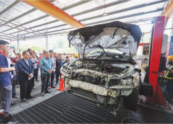 ANTHONY Loke melihat proses meleraikan kenderaan terpakai ketika lawatan kerja di Semenyih, semalam. 
– UTUSAN/AMIR KHALID
