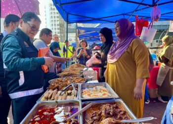 ASITS Sanna (kiri) melakukan pemeriksaan di Bazar Ramadan Lintasan Deasoka di Kota Kinabalu hari ini