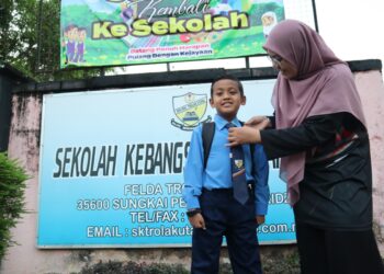 ATTAR AZIM Syukran Jamil bersama ibu saudaranya, Umi Salwa Ab. Hamid di hadapan Sekolah Kebangsaan (SK) Trolak Utara, Felda Trolak Utara, Sungkai semalam.