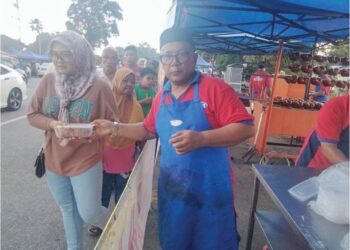 HAIRULIZAM Saat mengagihkan ayam golek percuma di gerai Zam Ayam Golek di Bazar Ramadan Pekan Ayer Baloi, Pontian.