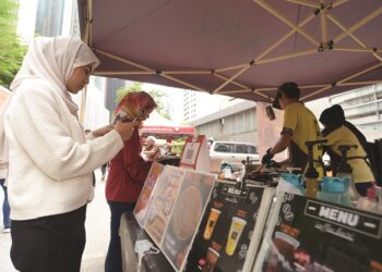 PeLANGGAN membuat bayaran dengan menggunakan kod QR pada Program Pelancaran Penjaja Cashless di Jalan Tengah, Kuala Lumpur, November tahun lalu. – MINGGUAN/SYAKIR RADIN