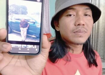 MOHD. Syukri Mohd Razif menunjukkan gambar kenangan arwah bapanya, Mohd Razif yang meninggal  ketika mengimamkan solat subuh semalam di Masjid Jamek Kampung Sermin, Segamat.