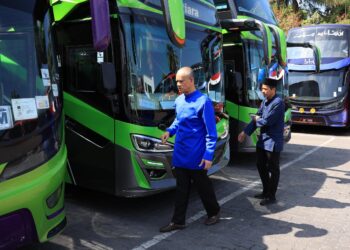 CHE Ibrahim Che Ismail (kiri) bersama pegawainya memeriksa keadaan bas E-Mutiara di Kota Bharu, Kelantan. -UTUSAN/KAMARUL BISMI KAMARUZAMAN