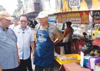 KAMALLUDIN Ismail (dua dari kanan) pada program tambah nilai e-wallet bazar Ramadan Rahmah di Manjung, Perak semalam.