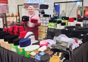 NUR AFIFA ROSLAN menunjukkan kepelbagaian songkok perniagaan Songkok Warisan Keluarga Sarbaini Jamil ketika ditemui di Seremban. 
– UTUSAN/NUR SHARIEZA ISMAIL