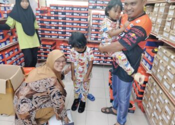 MOHD. Shawal Bachok dan isterinya, Zainuriah Jamel mencuba kasut untuk anaknya di sebuah pasar raya di Pusat Perdagangan Pontian,
di Pontian, Johor. – UTUSAN/MUHAMMAD ZIKRI
