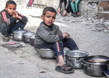 KAnak-kanak duduk di atas periuk yang kosong sementara menunggu bekalan makanan yang disediakan oleh pertubuhan kebajikan untuk berbuka puasa di Gaza, semalam. – AFP